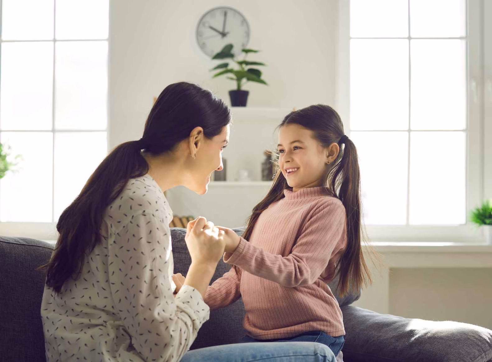 co-regulation school mother and child looking at each other smiling on sofa