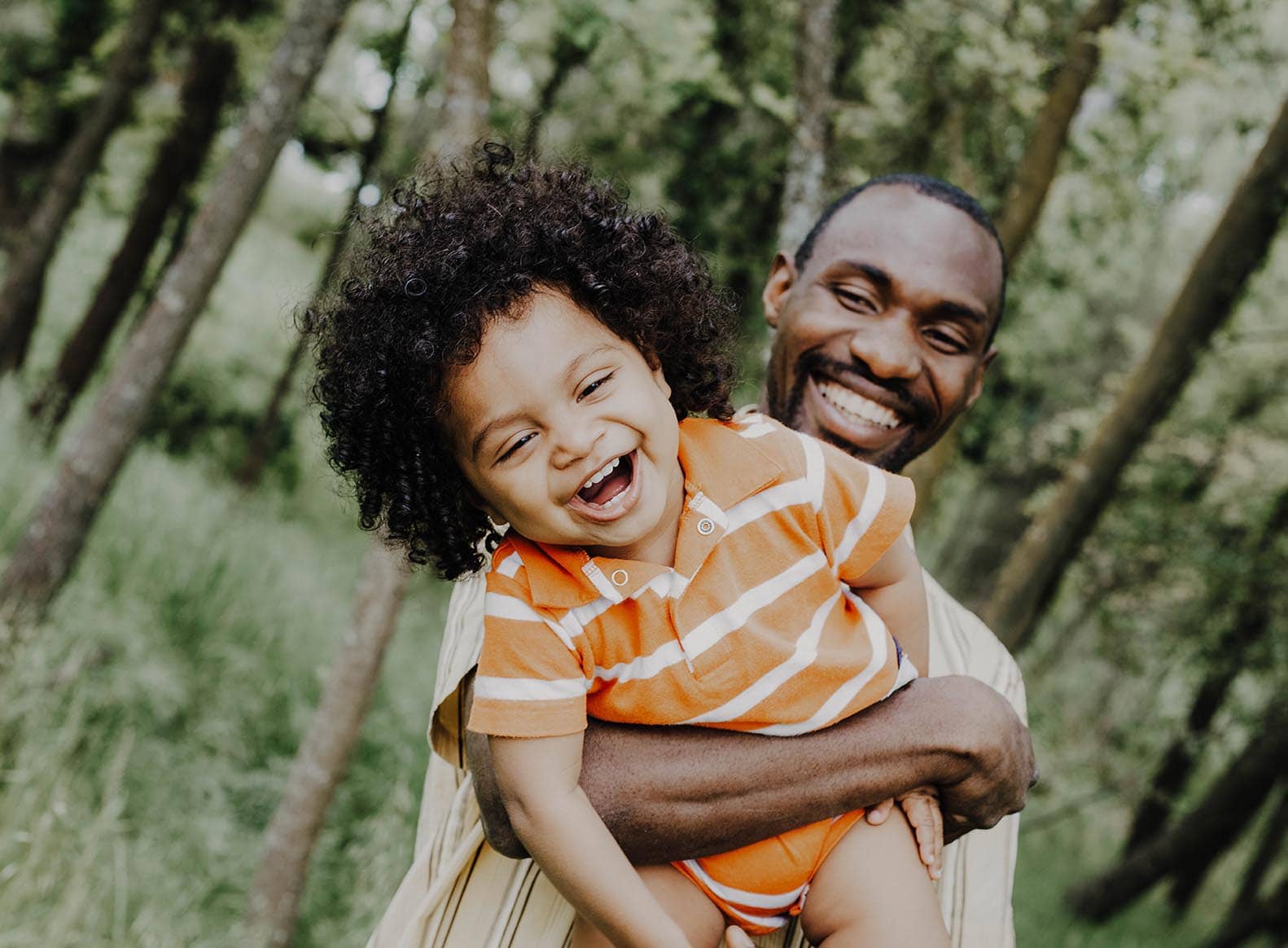 father holding child up, smiling, text, sensory strategies vs sensory integration